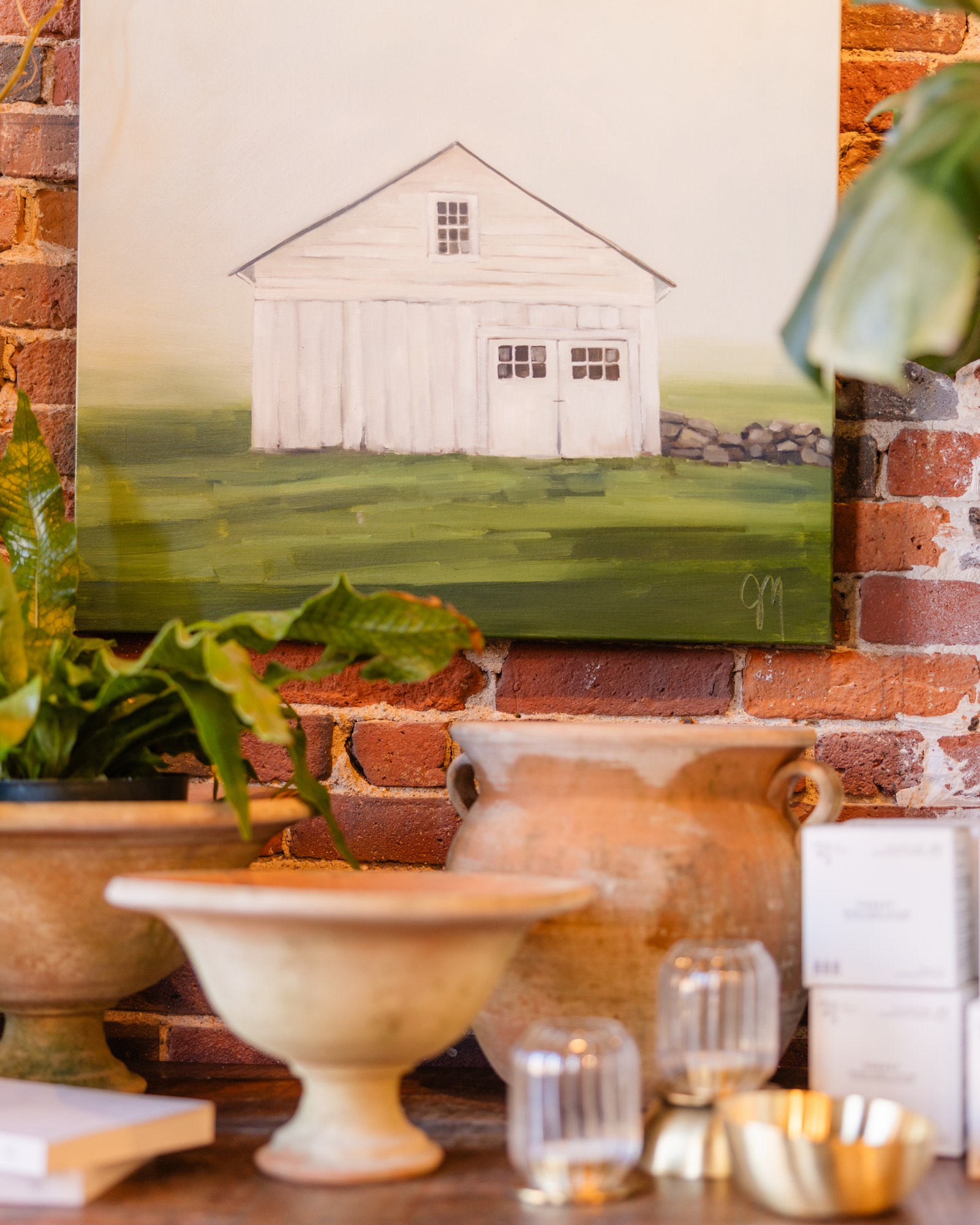 A barn painting and vessels against the brick wall