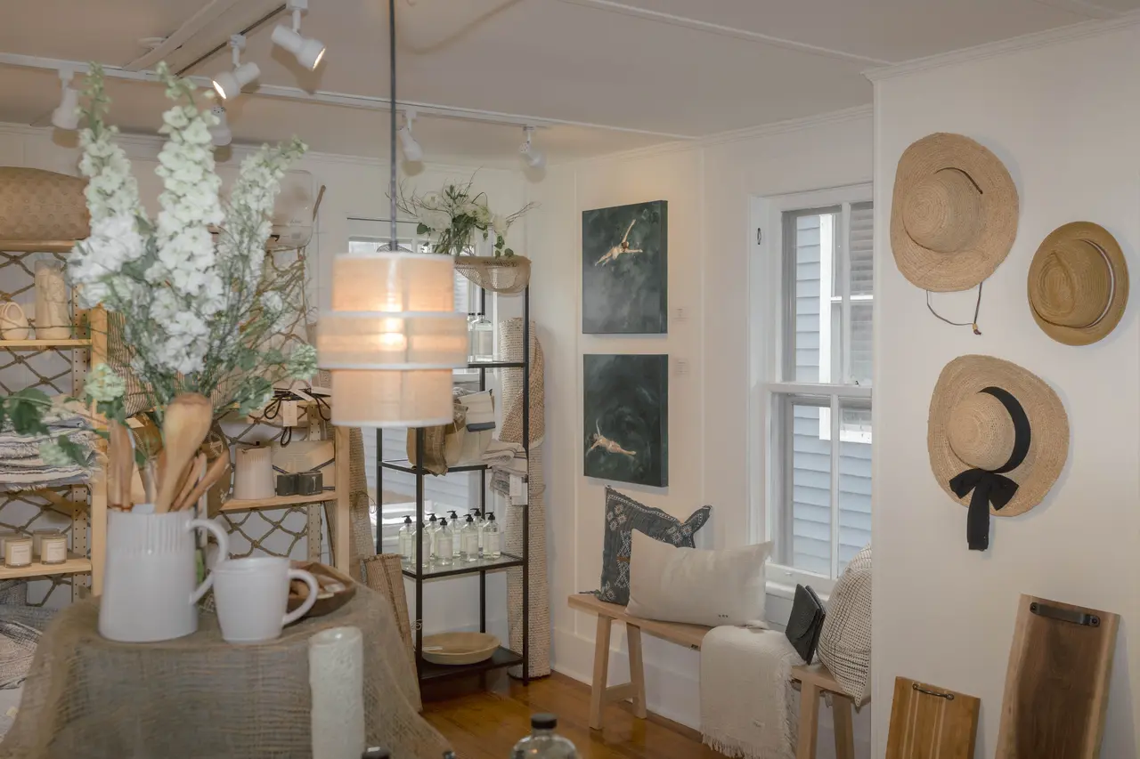 A styled corner at STELLAN: straw hats, ceramics, and dried florals against white shiplap