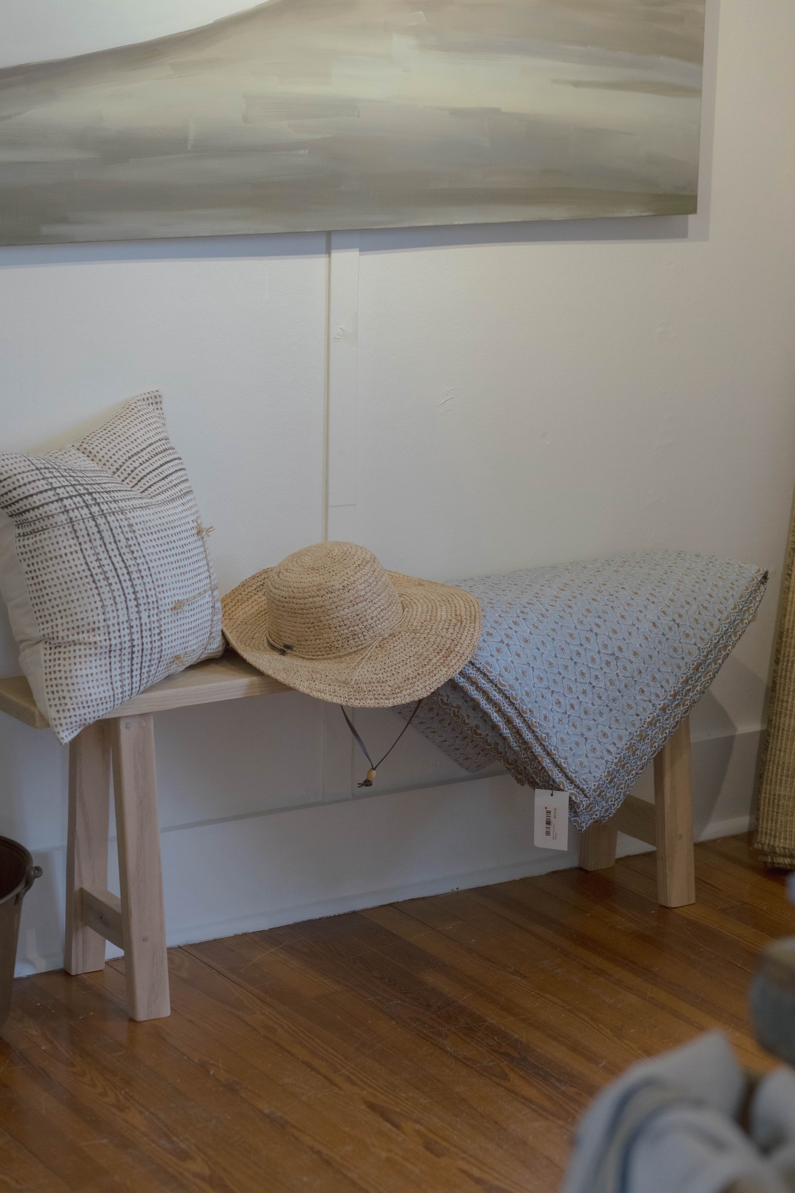 A straw hat and quilt on a bench at STELLAN